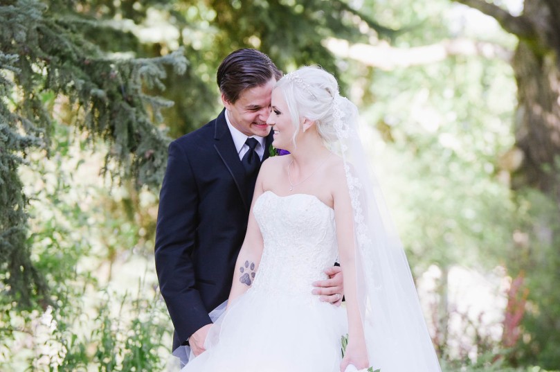 bride-and-groom-kiss-at-reader-rock-gardens-in-Calgary-Alberta-after-catholic-ceremony